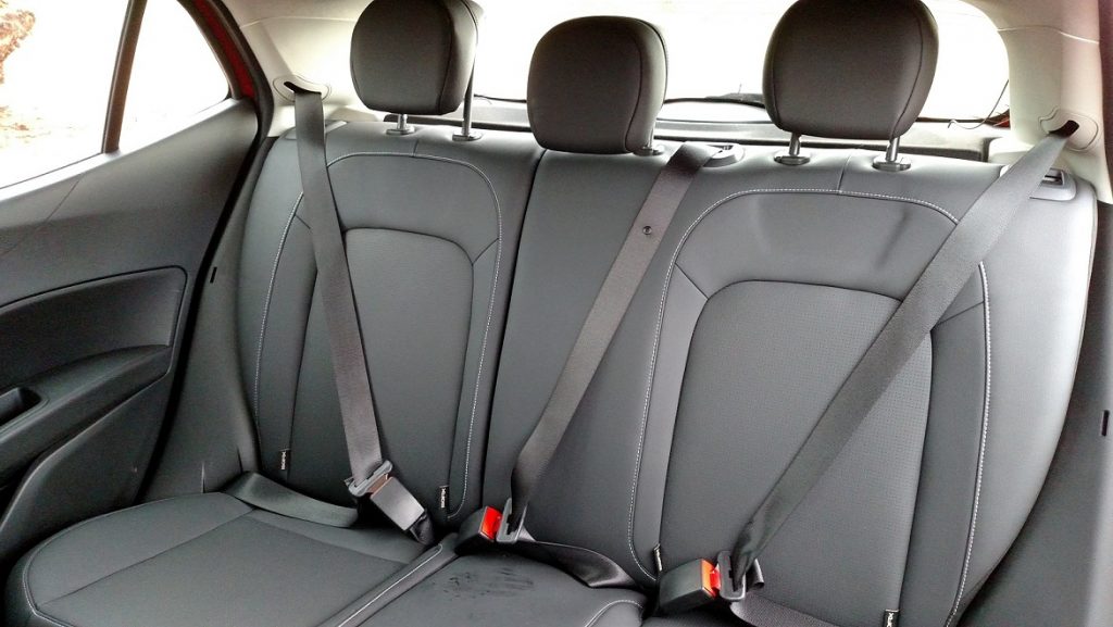 Dois adultos e uma criança viajam com conforto no banco traseiro