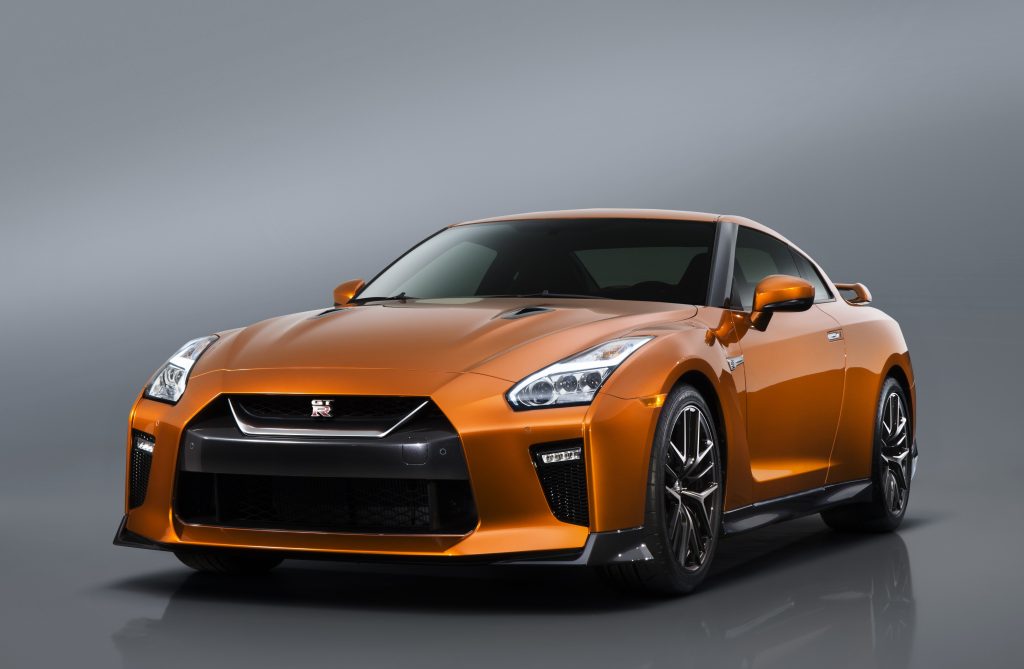 The 2017 GT-R's exterior receives a thorough makeover. The new V-motion grille, one of Nissan's latest design signatures, has been slightly enlarged to provide better engine cooling and now features a matte chrome finish and an updated mesh pattern. A new hood, featuring pronounced character lines flowing flawlessly from the grille, has been reinforced to enhance stability during high-speed driving. A freshly designed front spoiler lip and front bumpers with finishers situated immediately below the headlamps give the new GT-R the look of a pure-bred racecar, while generating high levels of front downforce.